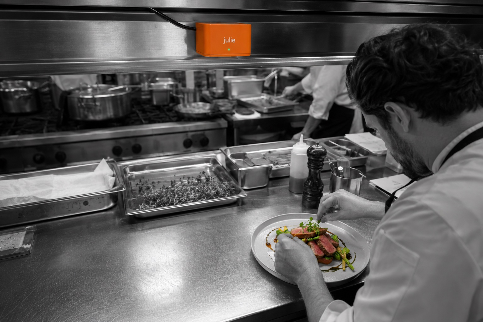 Julie above the pass while a chef plates